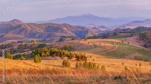Mountain view in sunset light, evening countryside, hills and meadows