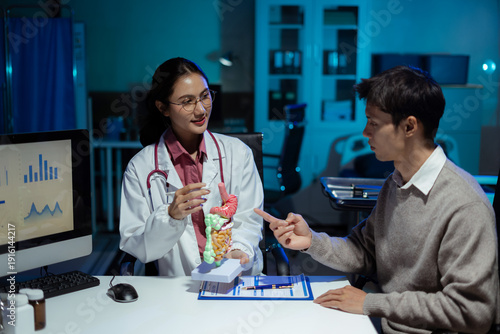 Fotografi doctor shows a model of how the intestines system works, doctors explaining symptoms and treatment to patients