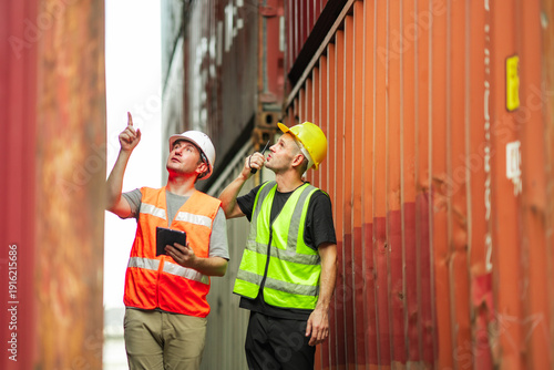 Photography Two cargo inspectors observe upper container levels and communicate via handheld radio