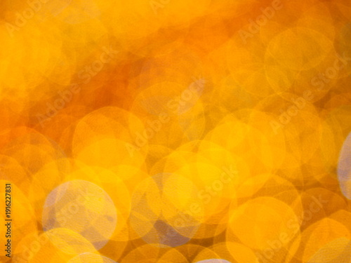 Abstract Bokeh from indoor lighting, Blue with orange with gold and yellow circles spread on  black colored surface, Night city light background for celebration of christmas and holiday season