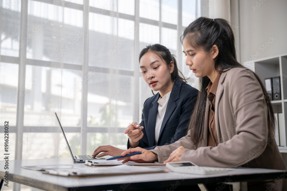 © Apichat - Asian businesswomen collaborating on laptop during office meeting © Apichat - Asian businesswomen collaborating on laptop during office meeting
