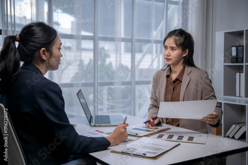 Fotografie Asian businesswomen discussing financial data in office meeting