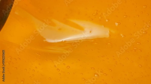 Stirring liquid honey with spoon, macro honey texture with air bubbles, slow motion.