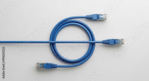 Blue Ethernet cable coiled on white background creating circular shape. Ethernet cable with RJ45 connectors provides high speed data connection for network infrastructure.