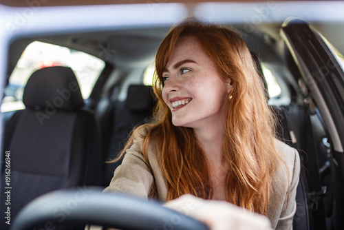 Photos Confident female driver checking blind spots and looking back while reversing a car