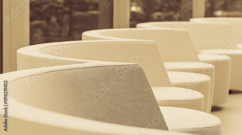 contrapositive. A minimalist, flowing arc of upholstered seating on a blurred neutral background. real-estate listings.