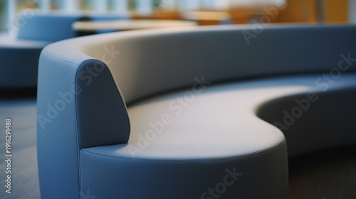 contrapositive. A minimalist, flowing arc of upholstered seating on a blurred neutral background. real-estate listings.