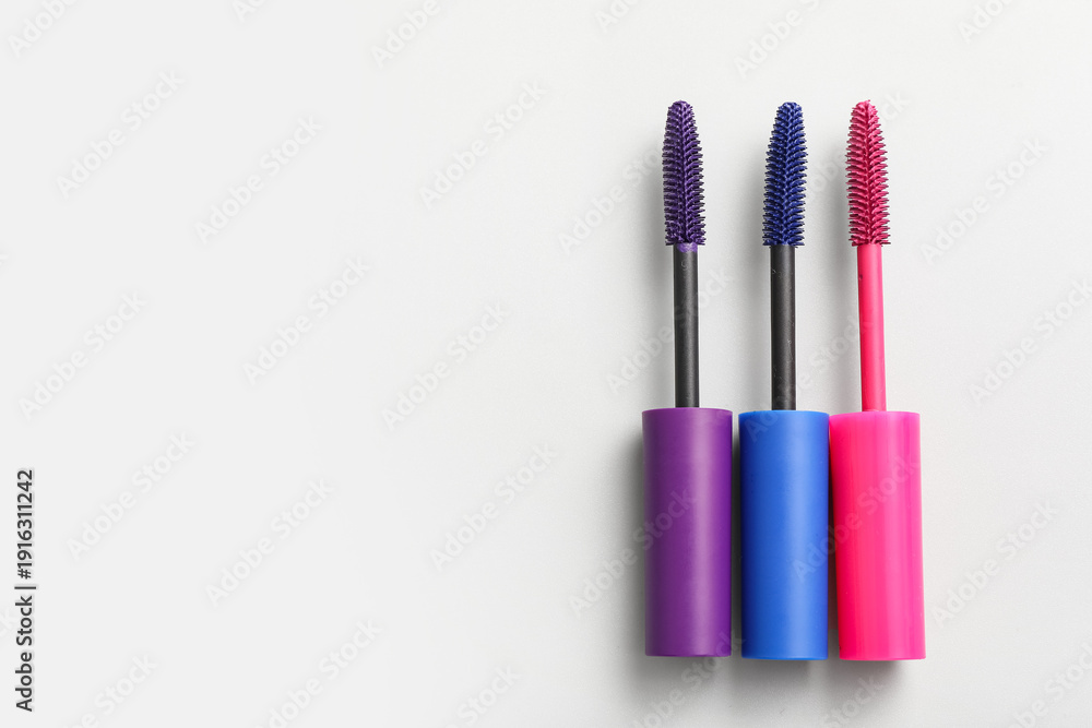 Fototapeta premium Brushes of different mascara on white background, closeup