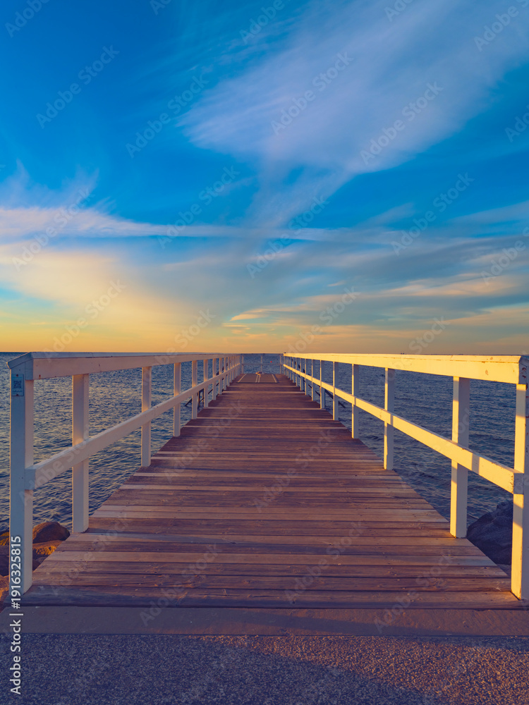 Fototapeta premium wooden bridge over the sea, sunset time