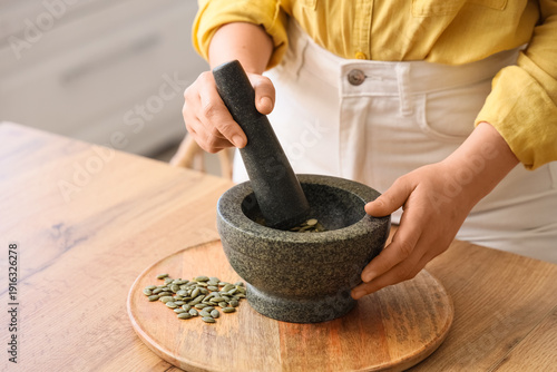 Woman grinding pumpkin seed...