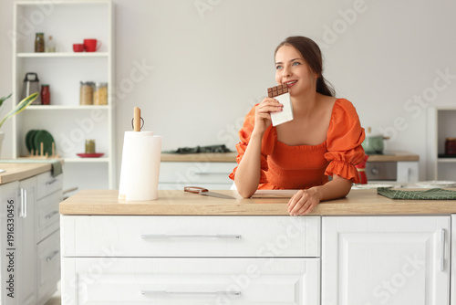 Young woman eating chocolat...