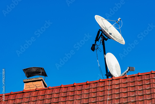 Bilde på lerret Satellite dishes on a rooftop against a clear blue sky