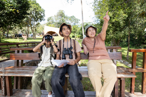 Photography Family Bird Watching Together with Mother Pointing at Birds in Nature Park