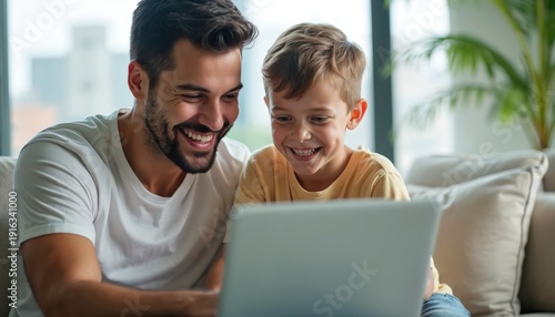 Wallpaper Mural Father and son laugh watching content on laptop together. Happy family bonding with technology in bright modern living room at home. Joyful boy and dad share computer fun on sofa. Torontodigital.ca