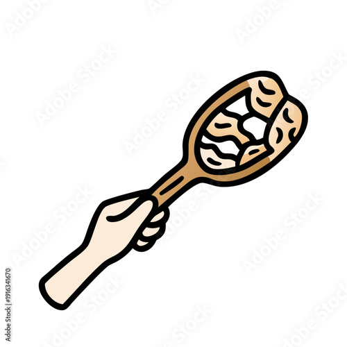 Hand holding a rustic wooden spoon with peanuts design

