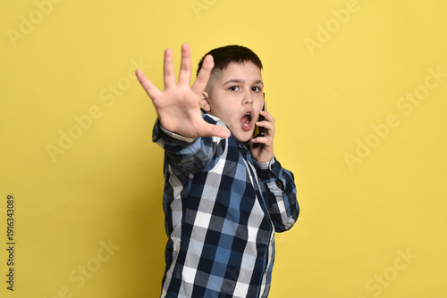 Young boy victim of phone harassment, showing the concept of cyberbullying and digital safety of children