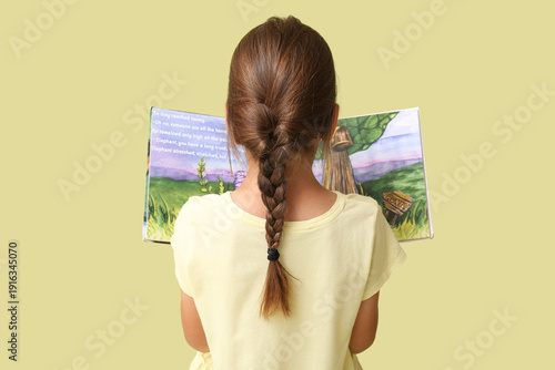 Cute little girl reading fa...