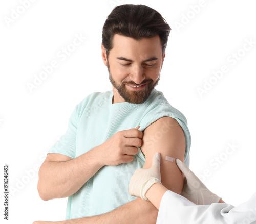 Young man with doctor's hands applying medical patch after vaccination on whi...