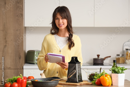 Young woman with recipe boo...