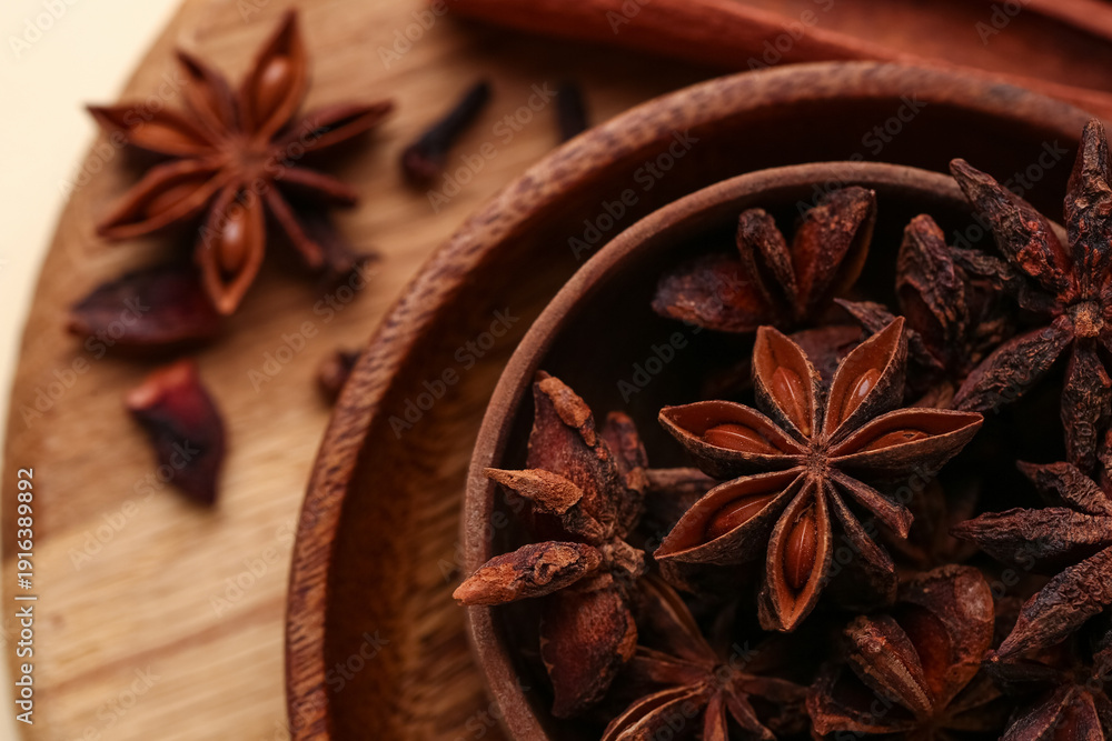 Fototapeta premium Wooden board with bowls of aromatic star anise, closeup