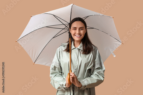 Happy young woman with umbr...