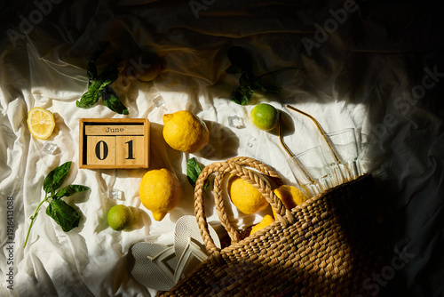 Εκτύπωση καμβά Lemons and lime are arranged artfully with fresh greens, ice cubes, and a woven basket, capturing a lively summer vibe in Italy on the first day of June