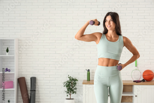 Young woman with dumbbells ...