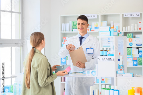 Male pharmacist with prescription medicine for customer at pharmacy