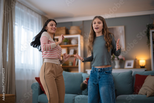 Mother and daughter dancing having fun at home