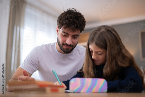 Tableau sur toile Father helping daughter with homework at home