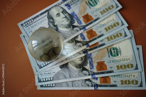 Wallpaper Mural A small glass globe and American dollars. Torontodigital.ca