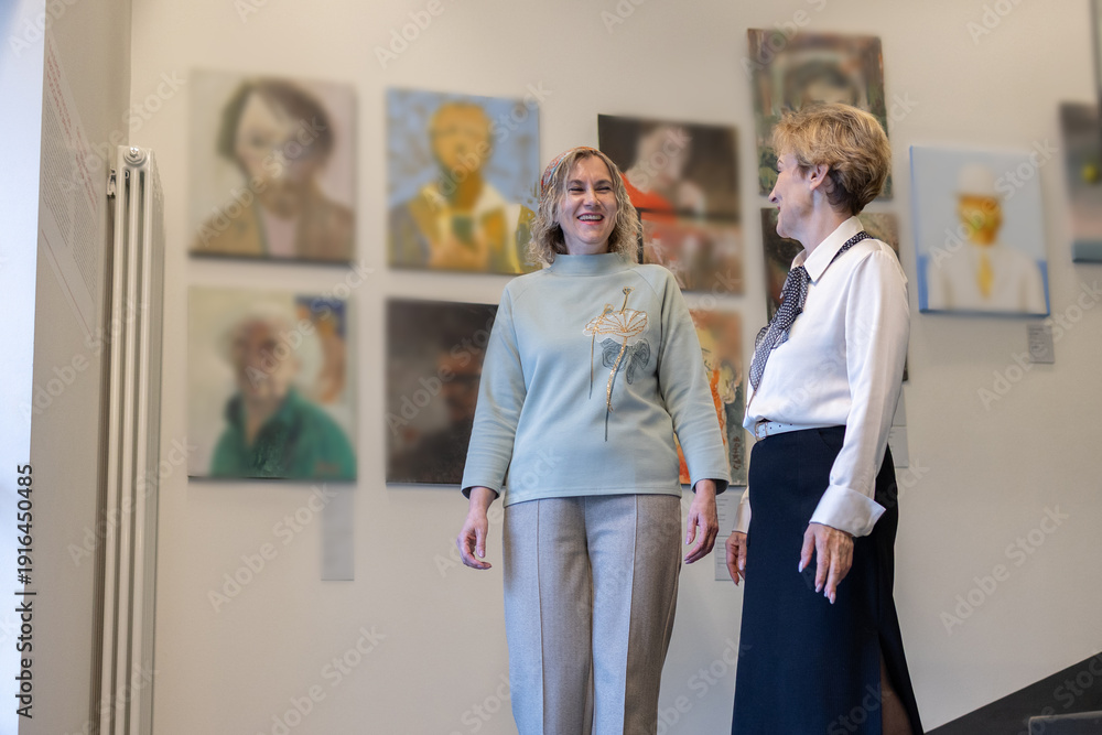 Fototapeta premium Two Women Viewing Art Exhibition In Gallery