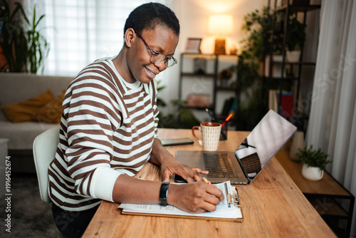 Wallpaper Mural Young adult woman working from home office writing Torontodigital.ca