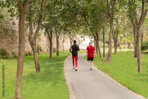 Wallpaper Mural Rear view of Personal trainer jogging with senior man in park Torontodigital.ca