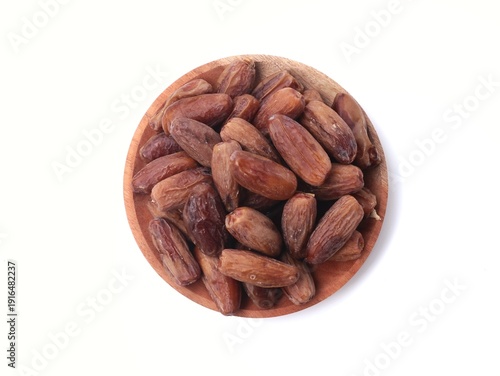 Top view of dried dates fruit on wooden plate Isolated on white background for Ramadan concept. Perfect for food packaging, Middle eastern cuisine themes, and Islamic holiday celebrations