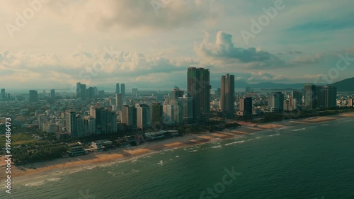sunny sunset in Vietnamese coastal Da Nang city, My Khe sand beach and touristic My An and Son Tra district with modern skyscraper hotels and resorts, blue sea of Danang, Vietnam, aerial drone view 4k