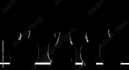 Silhouettes of Four Standing People with Subtle Light Effect, Dark Black Background