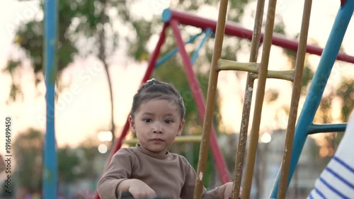 slow motion of cheerful child girl playing on double swing with her mother at outdoor playground