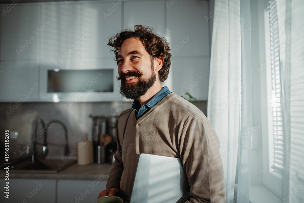 Fototapeta premium Smiling man working from home in morning light