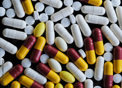 Large number of multi coloured pills, tablets or capsules. Prescription medicine, medication or drug misuse. Illness health treatment and cure  