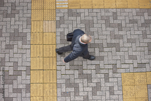 Konstfotografi ハイアングルで見た冬の都市の歩道で歩く中年ビジネスマンの姿
