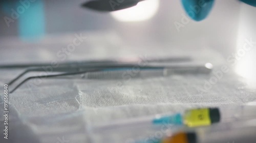 Surgeons hands carefully retrieve sterile scalpel from table laden surgical instruments, including tweezers syringe filled anesthesia, hospital operating room, preparing for precise medical operation
