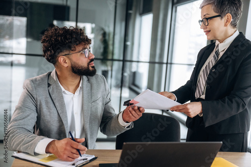 Εκτύπωση καμβά Business meeting in modern office with male employee in gray suit receiving docu