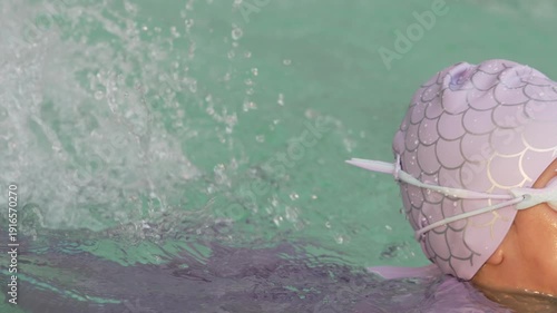 slow motion of preschool child girl playing and swimming in the pool