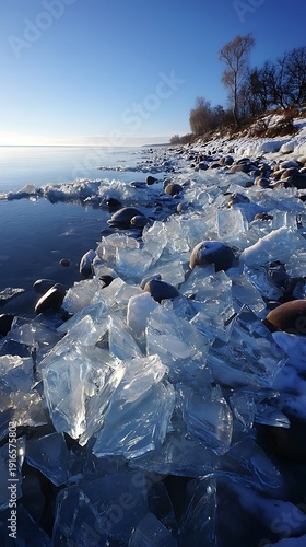 Frozen lake shore with ice formations and a clear blue sky in the background