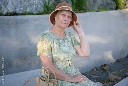 Senior woman in straw hat smiling outdoors portrait.