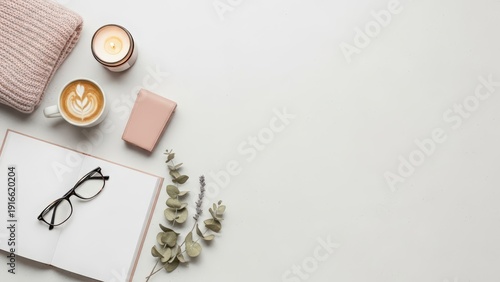 Serene wellness flatlay with lit candle, bar soap, eucalyptus, lavender, and open notebook on a clean surface