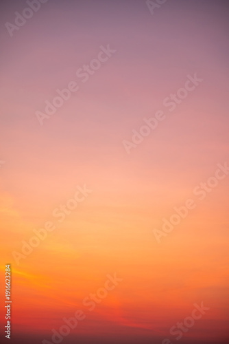 Beautiful sunrise sky with vibrant gradient orange and gold colors and soft blue, Clear atmosphere with wispy clouds. Peaceful, perfect for background and copy space, High resolution images Vertical