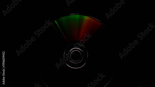 Abstract concept, The CD DVD spins gleaming colorful rainbow on a black background 