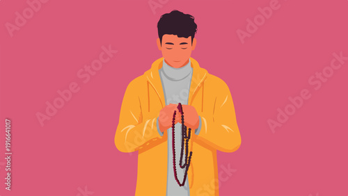 Young man wearing yellow jacket and praying with prayer beads